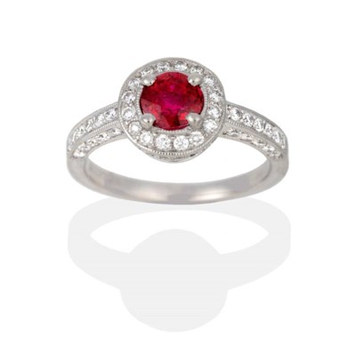 Lot 2040 - A Platinum Ruby and Diamond Cluster Ring, a round cut ruby in a claw setting, within a circular...