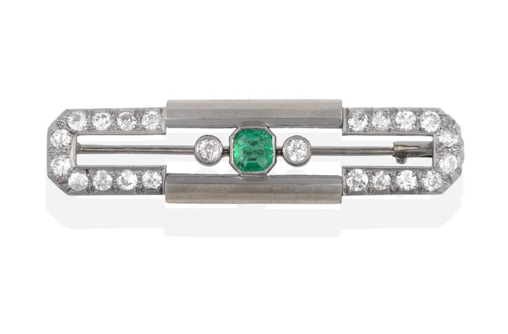 Lot 2083 - An Art Deco Emerald and Diamond Brooch, the geometric shape with an emerald-cut emerald and two old