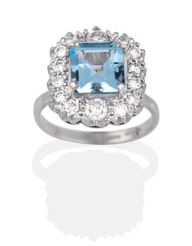 Lot 2085 - An Aquamarine and Diamond Cluster Ring, an octagonal cut aquamarine in a claw setting, within a...