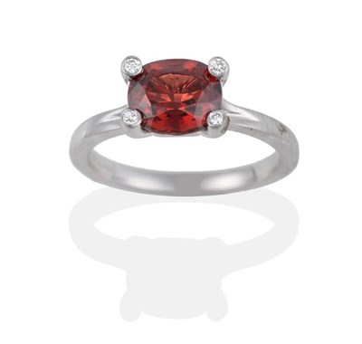 Lot 2093 - An 18 Carat White Gold Garnet and Diamond Ring, the oval mixed cut garnet in a four claw...