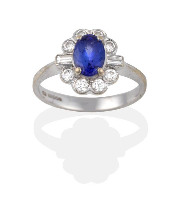 Lot 2098 - An 18 Carat White Gold Tanzanite and Diamond Cluster Ring, the oval cut tanzanite in four...
