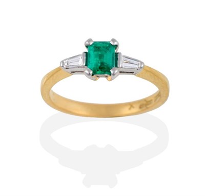 Lot 2155 - An 18 Carat Gold Emerald and Diamond Three Stone Ring, the emerald-cut emerald between two...