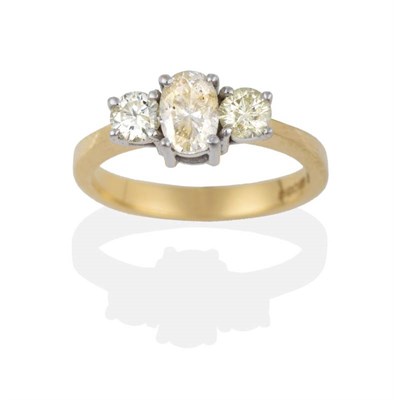 Lot 2160 - An 18 Carat Gold Diamond Three Stone Ring, an oval cut diamond between two round brilliant cut...