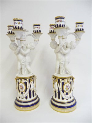 Lot 97 - A Pair of Minton Porcelain Three Branch Candlesticks, circa 1865, in the form of three white...