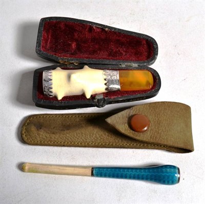 Lot 55 - An amber cheroot holder, cased; and a blue enamel and ivory cigarette holder in case (2)