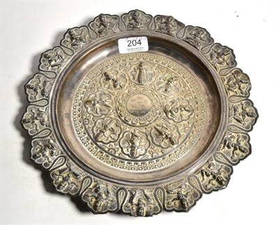 Lot 204 - An Indian white metal circular dish, unmarked circa 1900, decorated with panels of figures in...