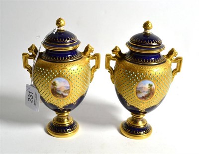 Lot 231 - A pair of Coalport blue ground and gilt decorated twin-handled pedestal vases, late 19th/early 20th