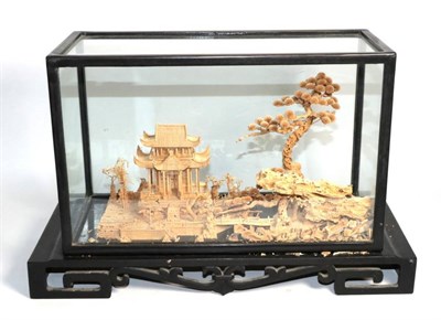 Lot 308 - A Japanese cork diorama depicting a pagoda within a landscape of trees, within a glass case,...