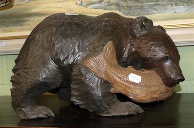 Lot 407 - A Black Forest style wooden carving of a bear catching fish