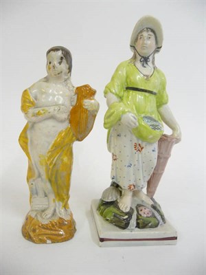 Lot 152 - A Pearlware Figure of a Fisherwoman, circa 1810, holding fish in her apron, a basket at her...