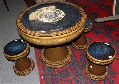 Lot 1184 - A Chinese ceramic circular pedestal table and three matching stools with foliate decoration