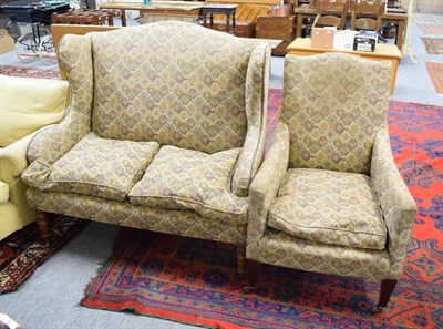 Lot 1189 - An upholstered Victorian wing back sofa and later chair with matching upholster