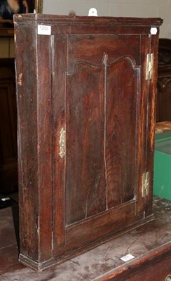 Lot 1202 - A George III corner cupboard, with some early timbers and carvings to reverse, of diminutive size