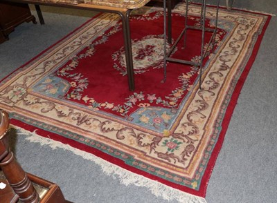 Lot 1233 - Indian ''Savonnerie'' carpet, the blood red field with floral medallion enclosed by leafy...