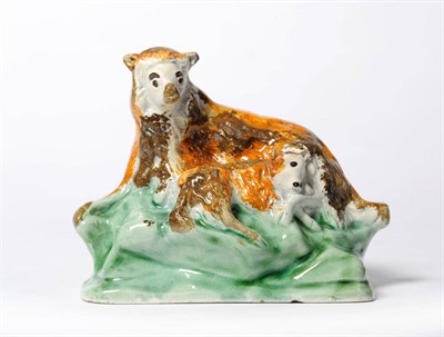 Lot 161 - A Prattware Figure of a Ewe and Lamb, circa 1800, the recumbent animals picked out in brown and...