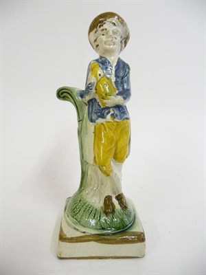 Lot 162 - A Prattware Figure, circa 1800, depicting a man holding a bottle, picked out in brown, blue, yellow