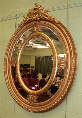 Lot 1263 - A gilt bevelled glass sectional oval mirror (modern), 136cm by 105cm