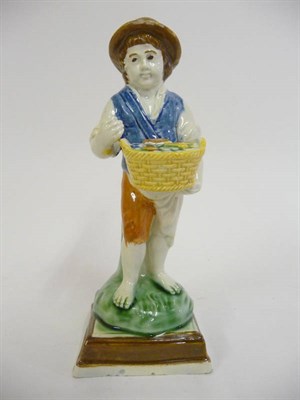 Lot 163 - A Prattware Figure of a Boy Holding a Basket of Food, square lined base, all picked out in...