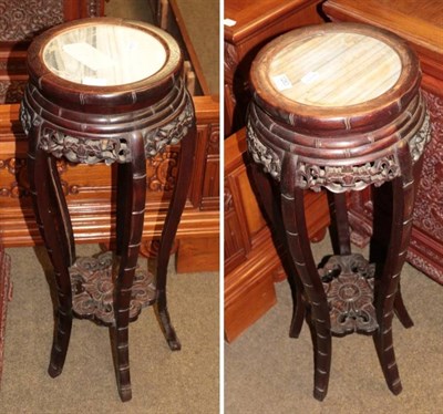 Lot 1283 - A pair of Chinese hardwood and marble circular plant stands (20th century)