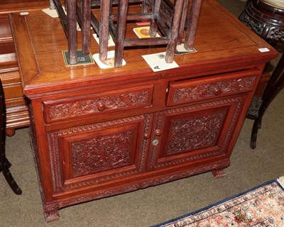 Lot 1289 - A 20th century Chinese hardwood sideboard, with two drawers above two cupboard doors (en suite...