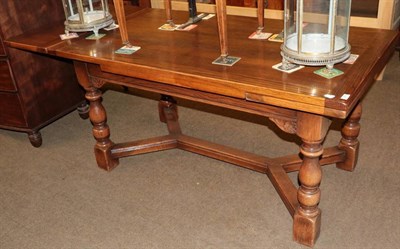 Lot 1298 - A solid oak drawleaf extending dining table, modern, of rectangular form, on baluster turned...