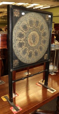 Lot 1299 - A 19th century ebonised firescreen, with glazed panel enclosing an 18th century silk work panel