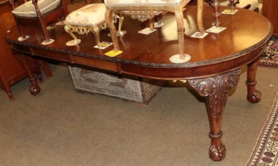 Lot 1306 - A carved mahogany extending dining table, circa 1900, of oval form with two additional leaves...