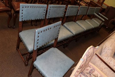 Lot 1335 - A set of eight 20th century oak dining chairs, upholstered in blue close nailed leather