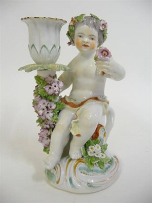 Lot 182 - A Derby Porcelain Figural Chamberstick, circa 1770, as a putto wearing loose drapes holding a...