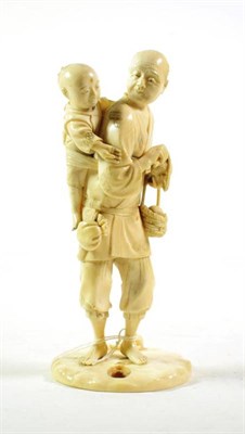 Lot 240 - A Japanese Meiji period ivory figure of a man peeling a piece of fruit