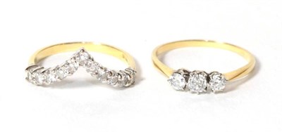 Lot 300 - An 18 carat gold diamond wishbone ring, finger size P1/2; together with a three stone diamond ring