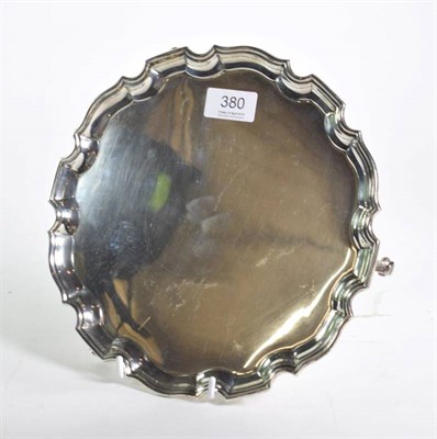 Lot 380 - A circular silver salver, Brook & Son (of Edinburgh), Sheffield 1932, on three scroll supports,...