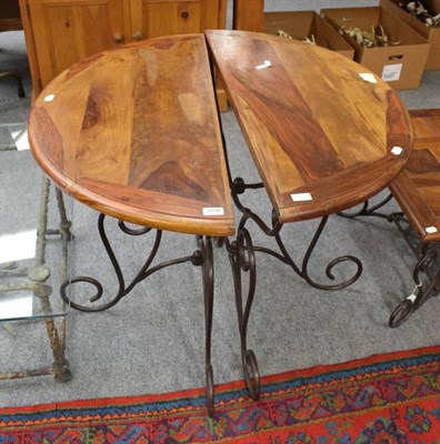 Lot 1150 - A pair of demi lune hardwood side tables with scrolled metal bases, each measures 89cm by 45cm...