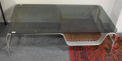 Lot 1179 - A mid 20th century modern coffee table with silvered metal base, glass top and a slung shelf