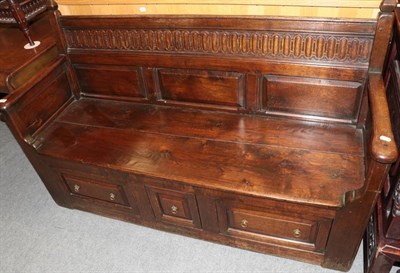 Lot 1268 - Carved oak settle, the back support with three moulded panels, the base with three drawers,...