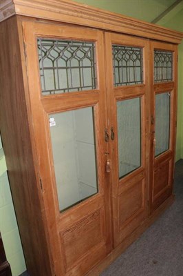Lot 1282 - A pine three door cupboard with painted interior and leaded glazed doors, composed of late 19th...