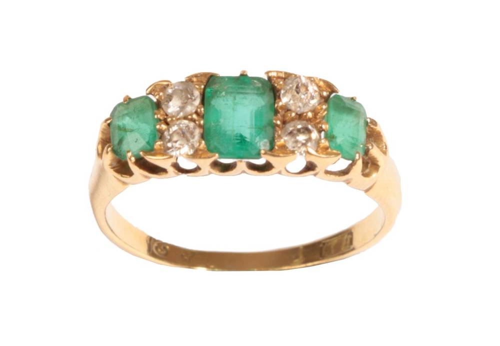 Lot 8 - An Emerald and Diamond Ring, the graduated emerald-cut emeralds alternate with pairs of old cut...