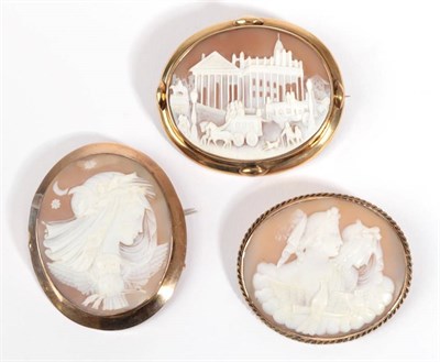 Lot 47 - Three Cameo Brooches, one depicting a scene with carriages, in an oval frame with lozenge detail at