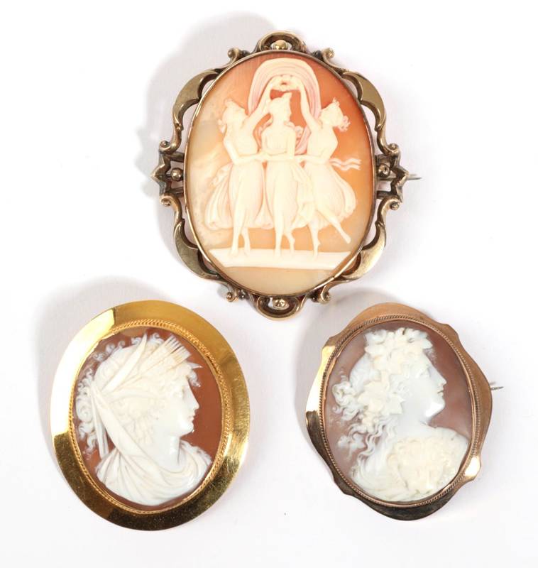 Lot 48 - Three Cameo Brooches, one depicting the three Graces, within a scrolling frame, measures 5.5cm...