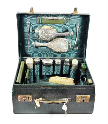Lot 62 - A Green Leather Vanity Case, early 20th century, containing various silver and other topped...