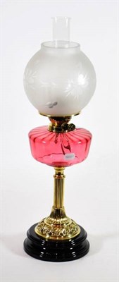 Lot 64 - A Brass Oil Lamp, late 19th century, with etched globe ruby glass reservoir and fluted column...