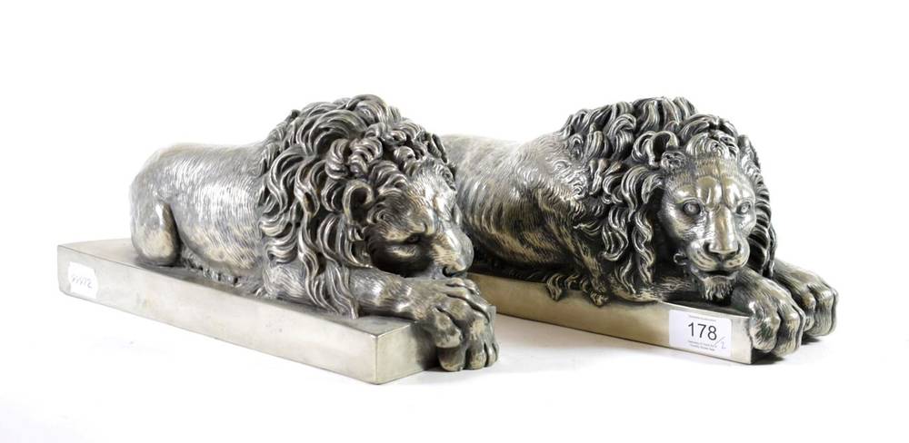 Lot 178 - A Pair of Silvered Metal Figures of Lions, after Antonio Canova, recumbent on rectangular...