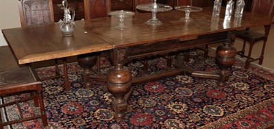 Lot 312 - A Jacobean Style Oak Drawleaf Dining Table, with a parquetry top and pull-out leaves above...