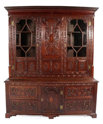 Lot 352 - A Carved Oak Bookcase, the dentil cornice above a central panel as a vase with trailing flowers...