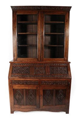 Lot 353 - A Carved Oak Bureau Bookcase, the carved cornice dated 1666 above glazed doors enclosing...