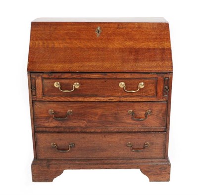 Lot 364 - An Oak Bureau, of small proportions, the fall front enclosing a cupboard door flanked by six...