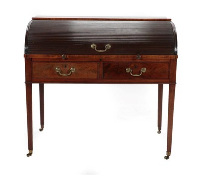 Lot 377 - A George III Mahogany Tambour Front Desk, circa 1800, the roll top enclosing a fitted interior...