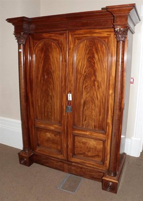 Lot 422 - ~ A Victorian Mahogany Breakfront Wardrobe, mid 19th century, the bold cornice above arched and...