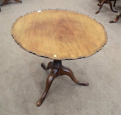 Lot 448 - ~ A Carved Mahogany Tripod Table, the associated pie crust fliptop on a gun barrel turned and...