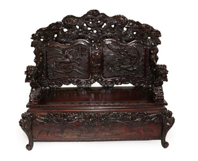 Lot 453 - A Chinese Carved Hardwood Bench, circa 1900, carved overall with dragons, with a panelled back...